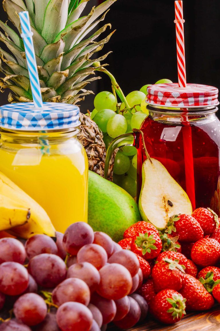 close-up-juicy-fruits-juice-jar-against-black-background