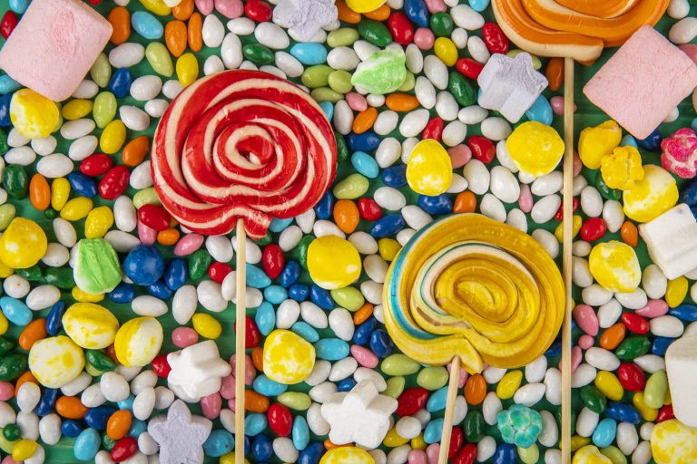 top view of  colorful lollipops on candies in multi-colored glaz